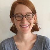 Anna Van Voorhis, a white woman with mid length red hair and glasses.