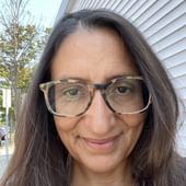 Camille Torres Hoven, white woman with long brown hair and glasses.